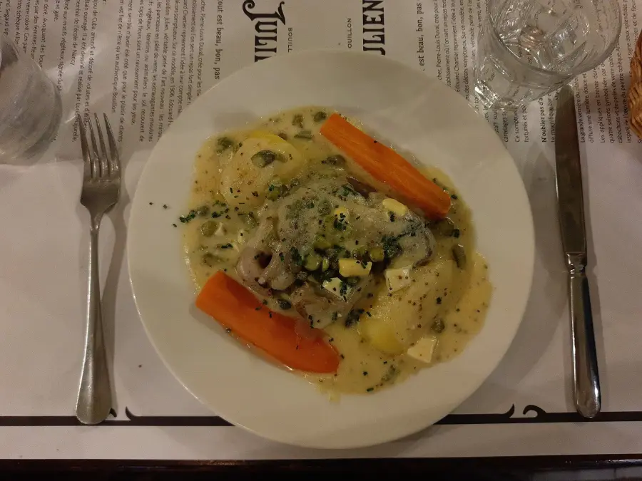 A creamy white stew of veal with carrots and potatoes in a white sauce, served in a bistro dish