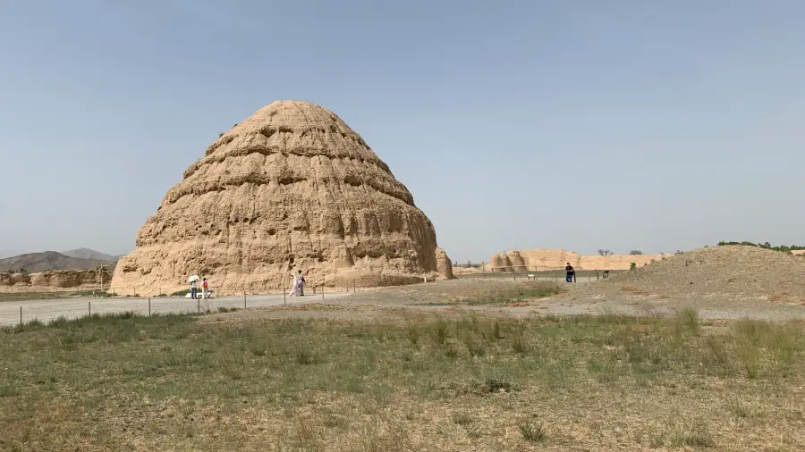 A weathered earthen Western Xia royal tomb on the dry gravel plain below the Helan Mountains in Ningxia, the same foothills where the region's vineyards are planted