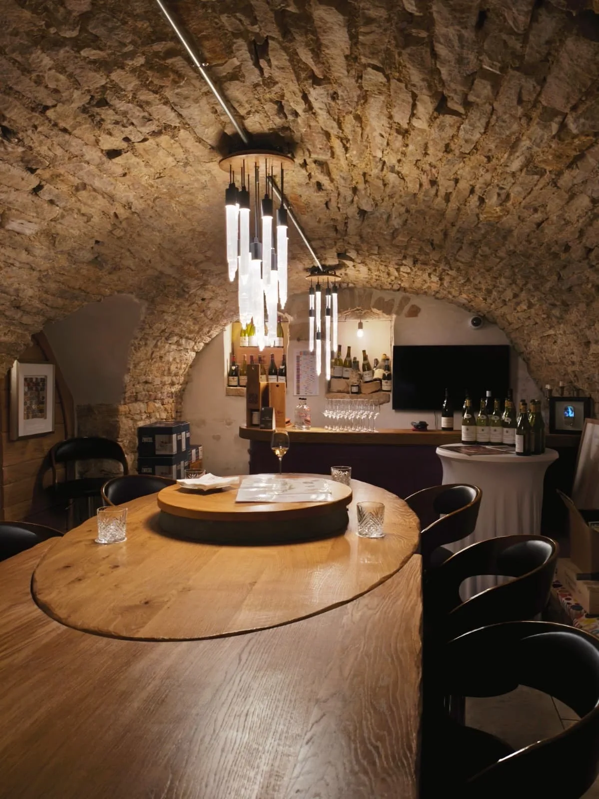Underground tasting cellar and 24-hour wine bar at Le Cep in Beaune with a round oak table