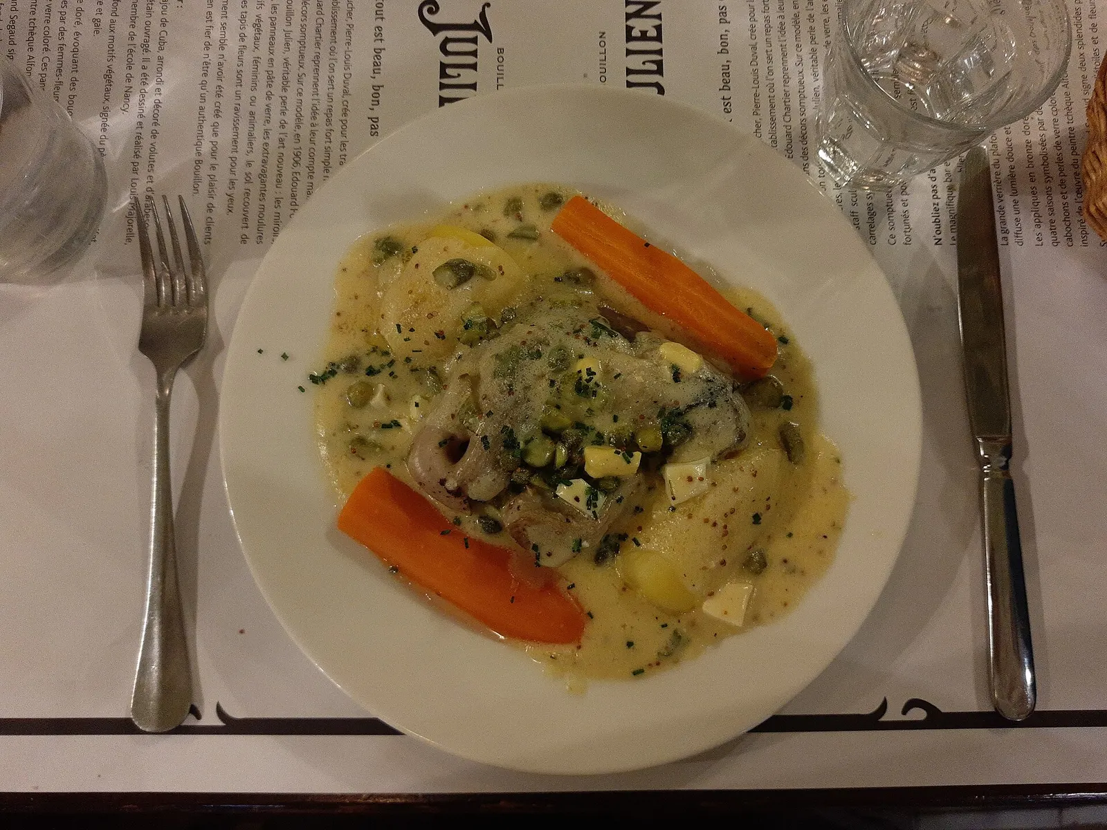 A creamy white stew of veal with carrots and potatoes in a white sauce, served in a bistro dish