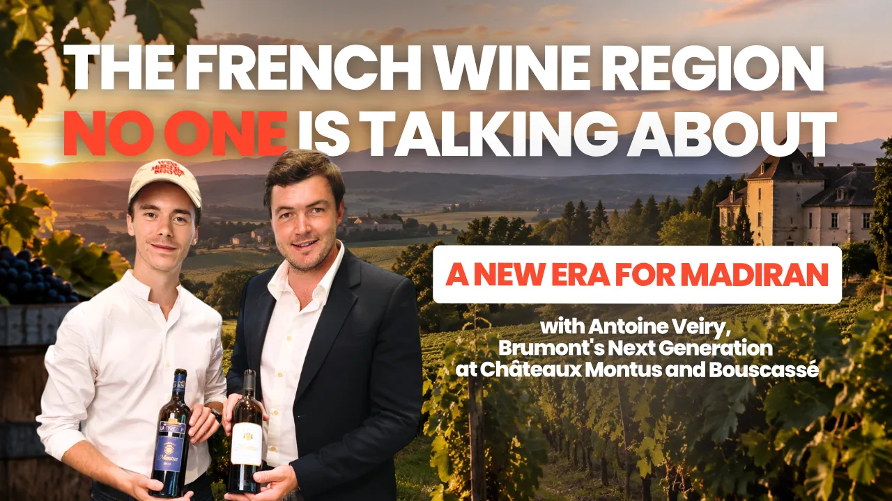 Antoine in a Wine Makers Show cap and Antoine Veiry, each holding a bottle from Château Montus and Château Bouscassé, in front of Madiran vineyards and a château at sunset