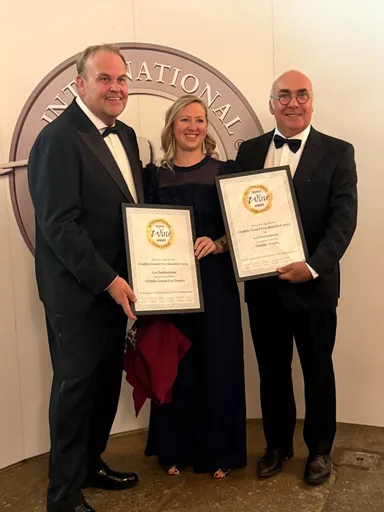 Estelle Roy à la cérémonie de l'International Wine Challenge 2026 à Londres, entourée de deux collègues tenant les certificats encadrés du Trophy du Chablis Grand Cru Blanchot