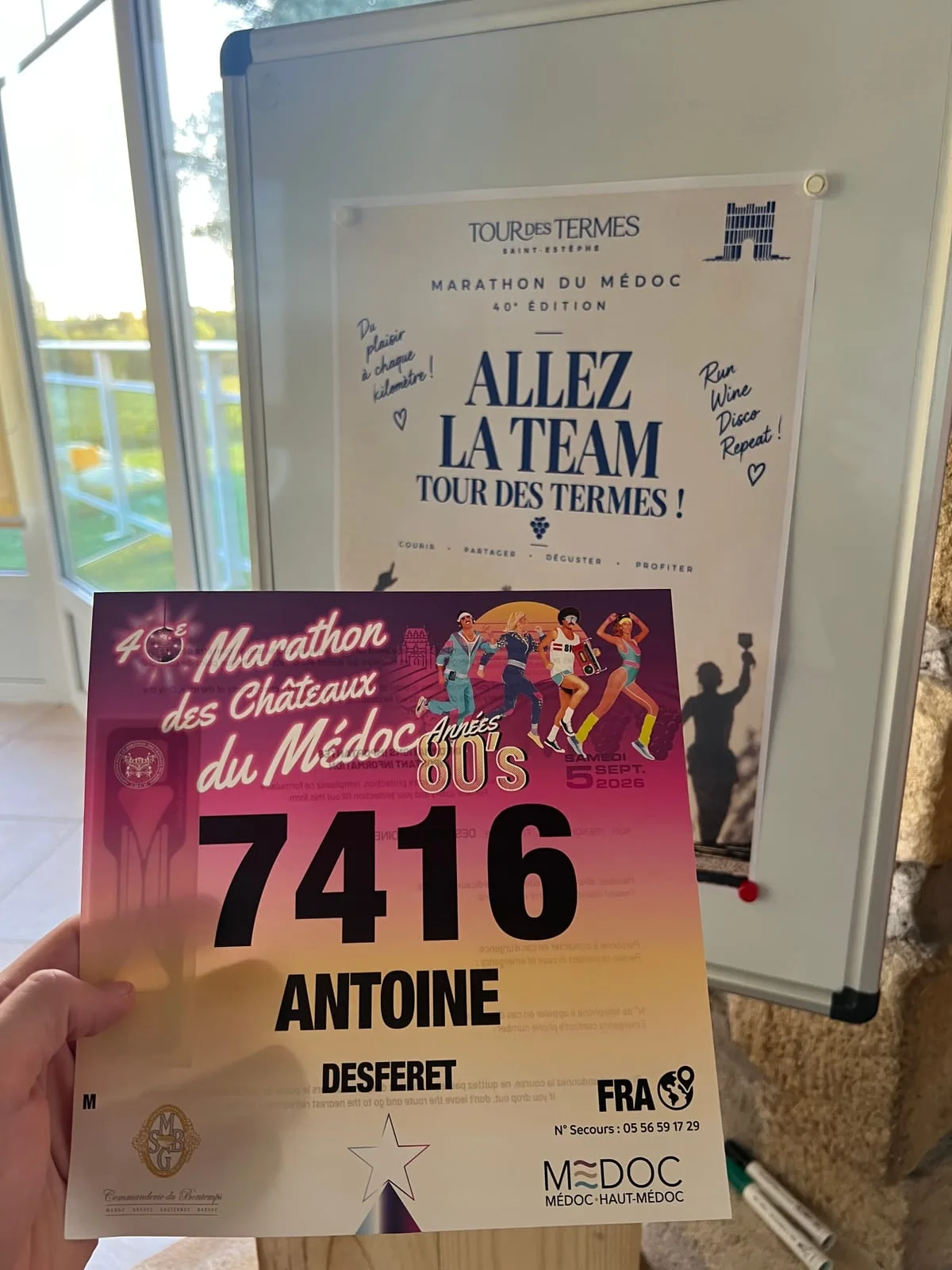 A race bib reading 7416, Antoine Desferet, 40th Marathon des Châteaux du Médoc, années 80's, Saturday 5 September 2026, held in front of a Tour des Termes poster reading Allez la team